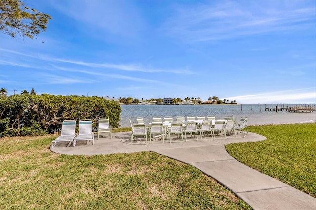 view of property's community featuring a patio area, a yard, and a water view