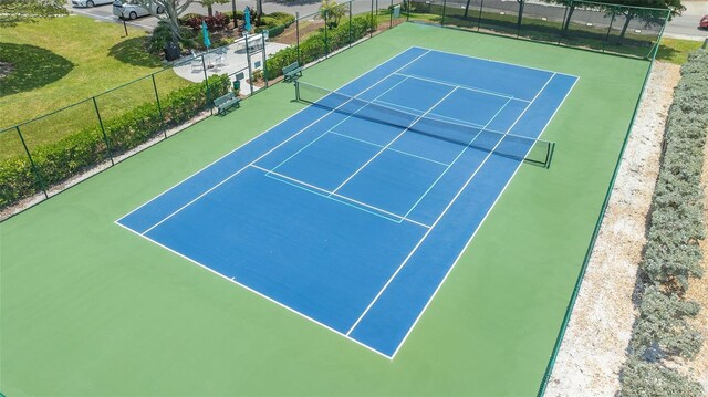 view of tennis court featuring basketball court and a yard