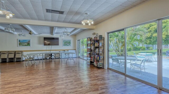 interior space featuring ceiling fan with notable chandelier and wood-type flooring