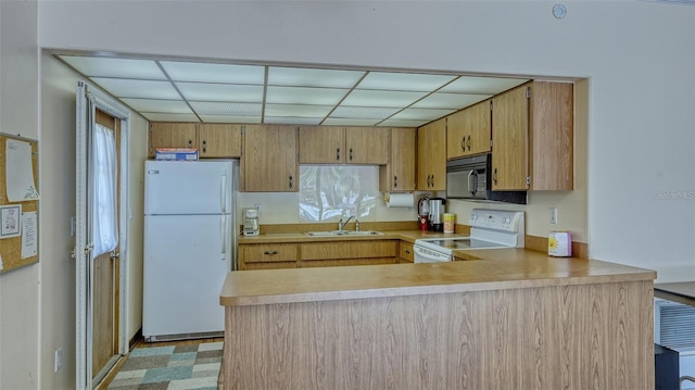 kitchen featuring kitchen peninsula, a paneled ceiling, sink, and white appliances