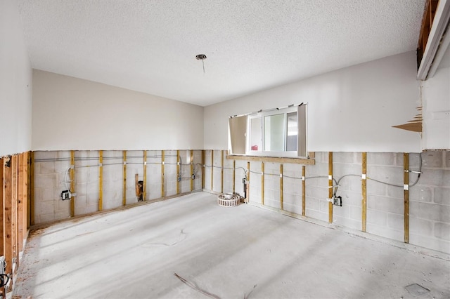 spare room featuring concrete flooring and a textured ceiling