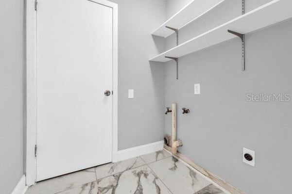 clothes washing area featuring marble finish floor, laundry area, baseboards, and hookup for an electric dryer