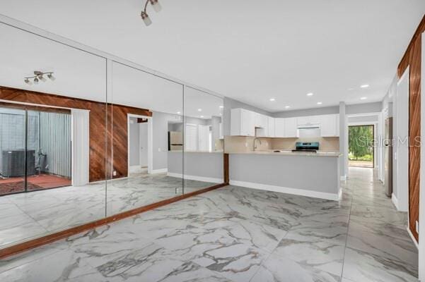 1502 NE Buckeye Rd NE Unit 2, Winter Haven, FL 33881 - interior space with decorative light fixtures, white cabinetry, marble finish floor, light countertops, and stainless steel range with electric stovetop