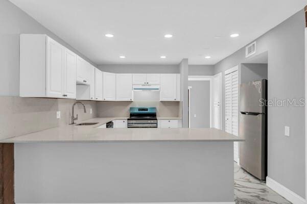 1502 NE Buckeye Rd NE Unit 2, Winter Haven, FL 33881 - kitchen featuring appliances with stainless steel finishes, marble finish floor, light countertops, white cabinetry, and a sink