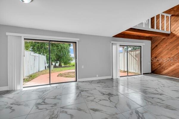 1502 NE Buckeye Rd NE Unit 2, Winter Haven, FL 33881 - spare room featuring marble finish floor, plenty of natural light, wooden walls, and baseboards