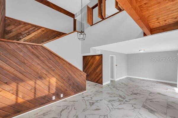 1502 NE Buckeye Rd NE Unit 2, Winter Haven, FL 33881 - unfurnished living room featuring marble finish floor, wood walls, and baseboards
