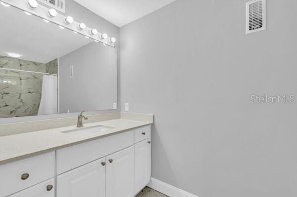 1502 NE Buckeye Rd NE Unit 2, Winter Haven, FL 33881 - bathroom featuring vanity, visible vents, baseboards, marble finish floor, and a marble finish shower