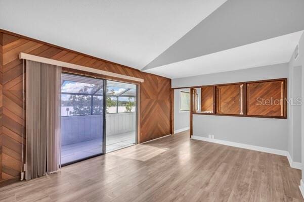1502 NE Buckeye Rd NE Unit 2, Winter Haven, FL 33881 - empty room featuring light wood-style floors, wooden walls, and vaulted ceiling