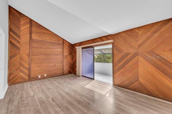 1502 NE Buckeye Rd NE Unit 2, Winter Haven, FL 33881 - spare room featuring wooden walls, vaulted ceiling, and wood finished floors