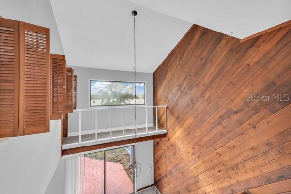 1502 NE Buckeye Rd NE Unit 2, Winter Haven, FL 33881 - staircase with a healthy amount of sunlight, wooden walls, and a towering ceiling