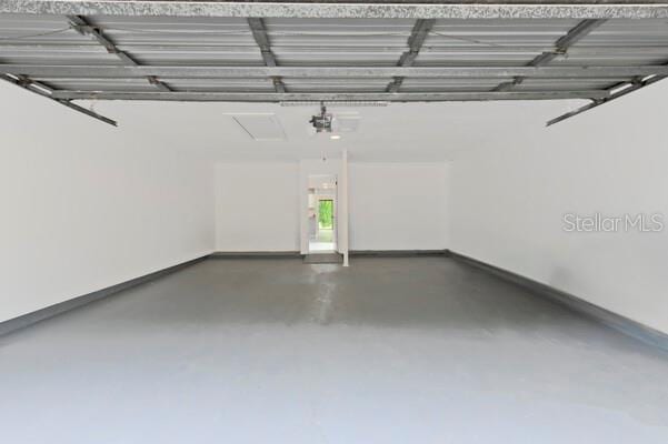1502 NE Buckeye Rd NE Unit 2, Winter Haven, FL 33881 - garage featuring a garage door opener and baseboards