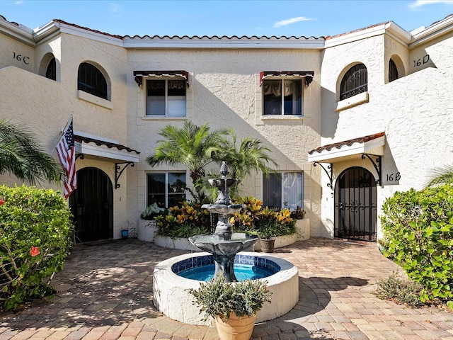 view of front facade featuring stucco siding and a tiled roof