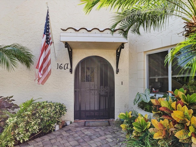 entrance to property featuring stucco siding