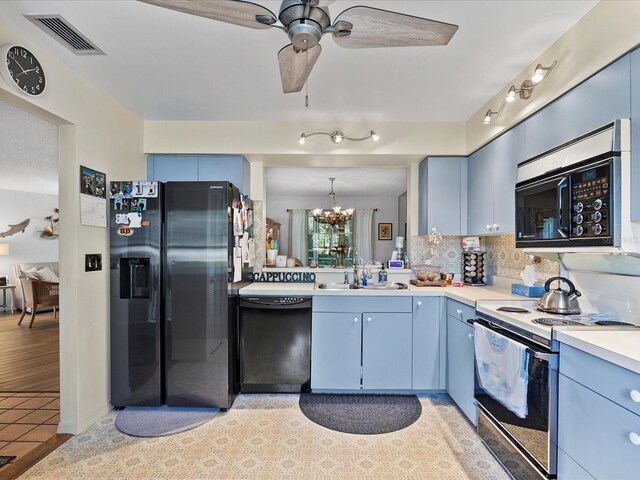 kitchen with sink, decorative backsplash, ceiling fan with notable chandelier, light tile patterned floors, and black appliances