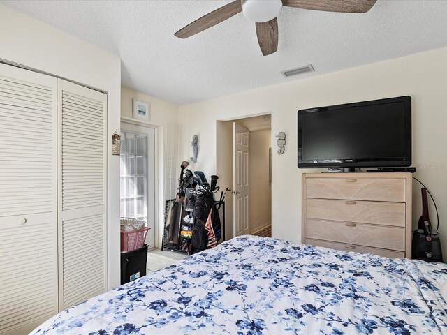 carpeted bedroom with a textured ceiling, a closet, and ceiling fan