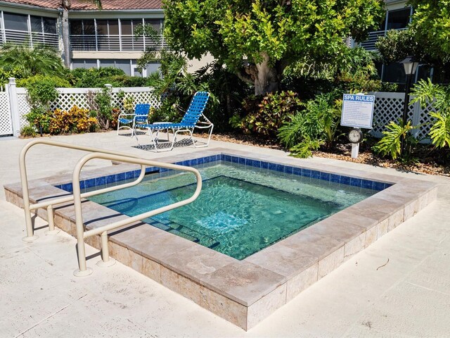 view of swimming pool with a hot tub and a patio area