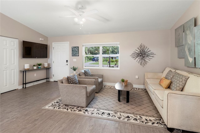 living room with ceiling fan, lofted ceiling, and hardwood / wood-style floors