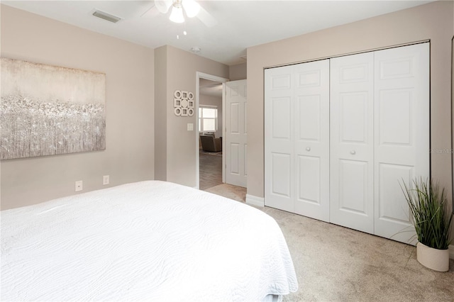 carpeted bedroom with ceiling fan and a closet