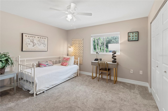 bedroom with light colored carpet, ceiling fan, and a closet