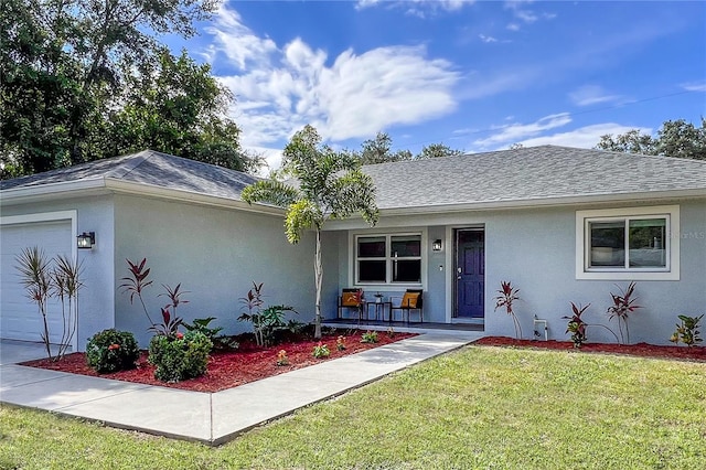 single story home with a front lawn, a porch, and a garage