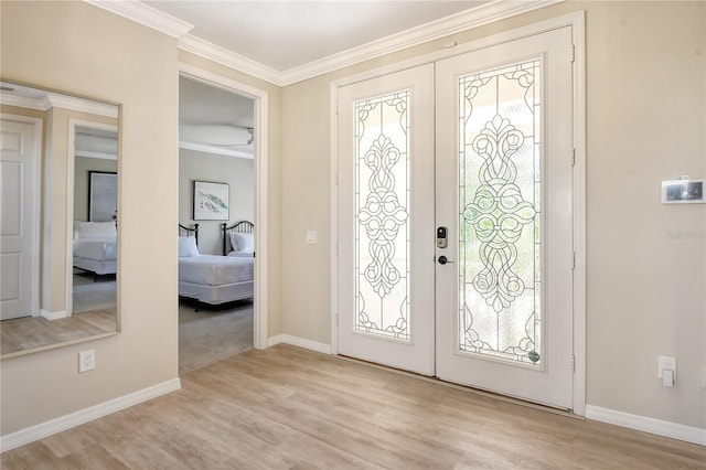 entrance foyer featuring light hardwood / wood-style flooring, crown molding, a healthy amount of sunlight, and french doors