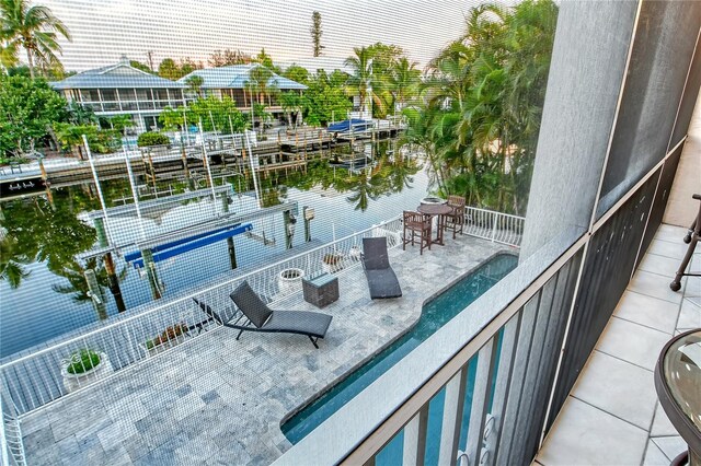 balcony with a patio, a boat dock, and a pool