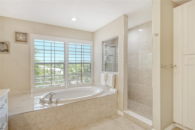 bathroom featuring tile patterned flooring, independent shower and bath, and vanity