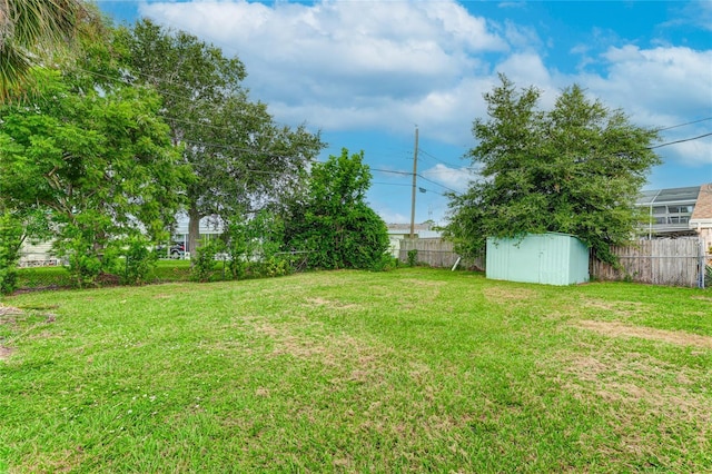 view of yard with a storage shed, an outbuilding, and a fenced backyard