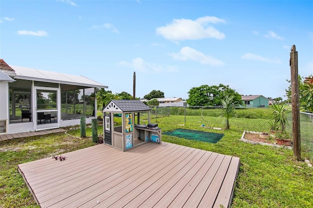 wooden deck featuring a sunroom and a lawn