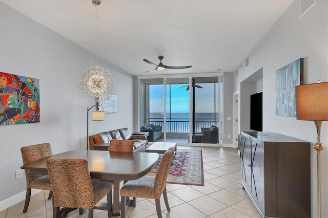 dining area featuring light tile patterned floors, expansive windows, baseboards, and a ceiling fan