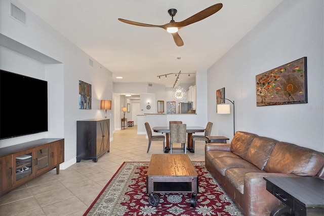 living room featuring light tile patterned floors, rail lighting, visible vents, ceiling fan, and baseboards