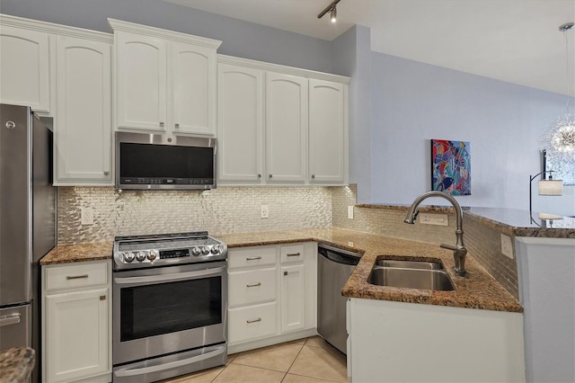 kitchen with a peninsula, white cabinetry, and stainless steel appliances