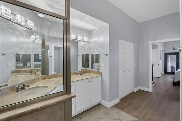 ensuite bathroom featuring ensuite bathroom, a closet, a sink, and baseboards