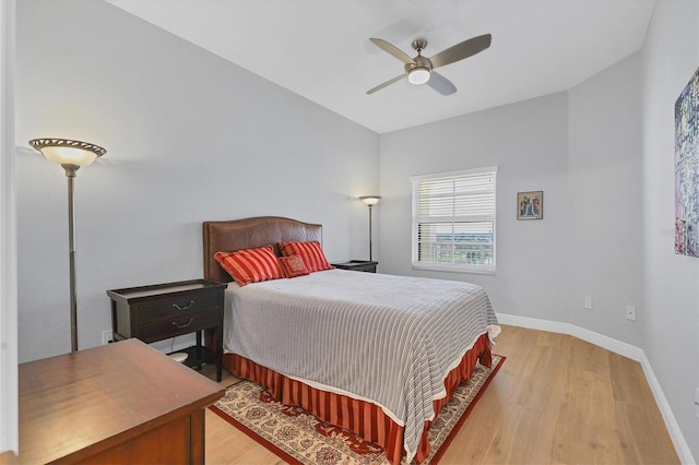 bedroom with light wood-style flooring, baseboards, and a ceiling fan