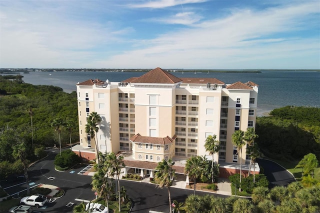 view of property with uncovered parking and a water view