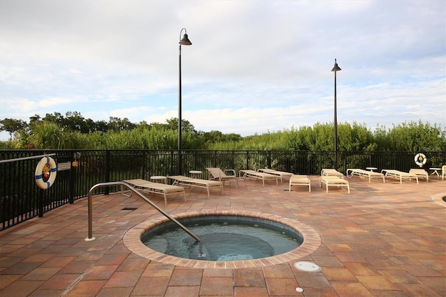 view of swimming pool featuring a patio area, fence, and a hot tub