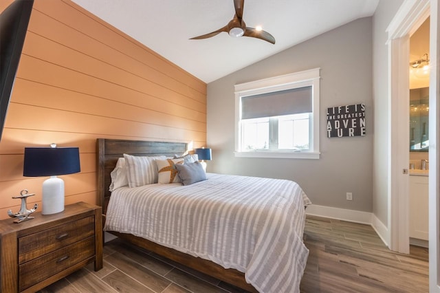 bedroom featuring ceiling fan, vaulted ceiling, hardwood / wood-style floors, and ensuite bathroom