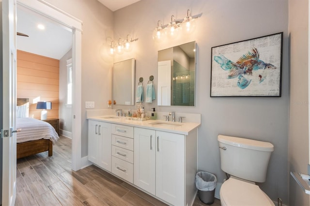 bathroom with hardwood / wood-style floors, dual vanity, and toilet