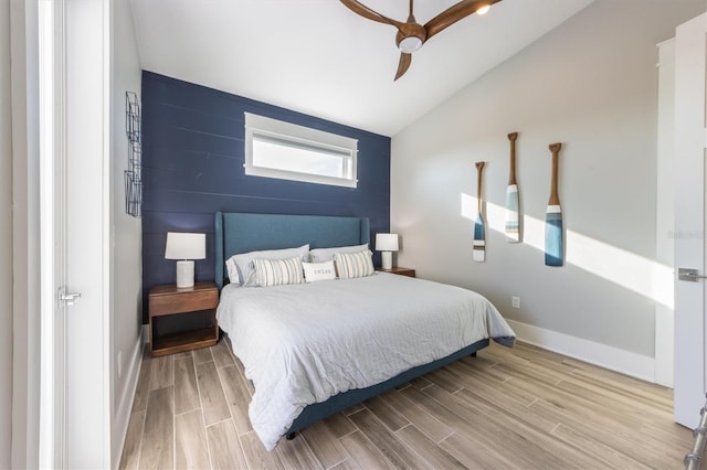 bedroom with light hardwood / wood-style flooring, ceiling fan, and vaulted ceiling