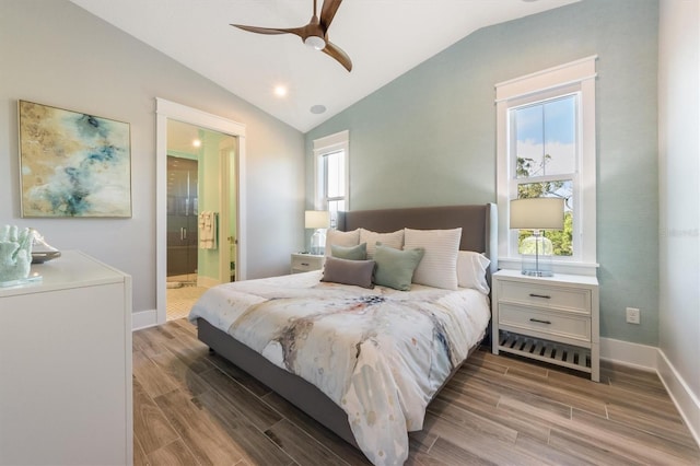 bedroom with ceiling fan, vaulted ceiling, connected bathroom, and wood-type flooring