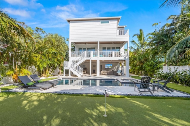 rear view of house featuring a balcony, a patio, and a pool with hot tub