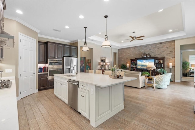 kitchen featuring light hardwood / wood-style flooring, stainless steel appliances, an island with sink, ceiling fan, and white cabinets