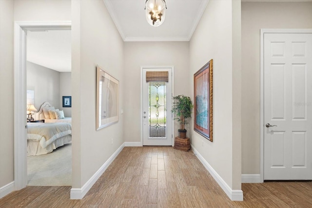 foyer with ornamental molding and light hardwood / wood-style floors