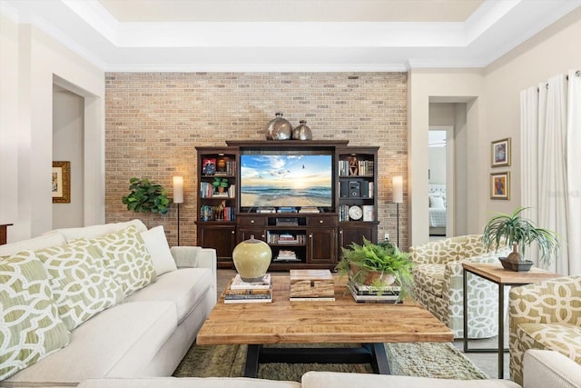 living room featuring ornamental molding and brick wall