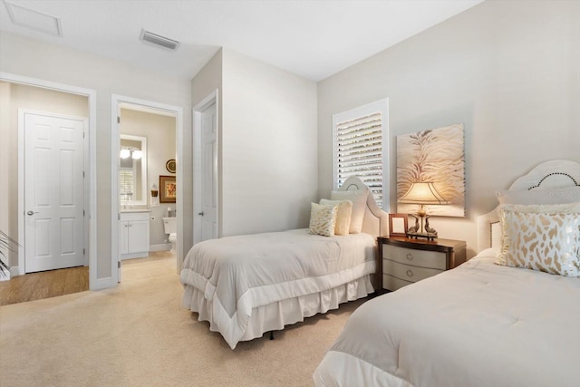 carpeted bedroom featuring ensuite bath