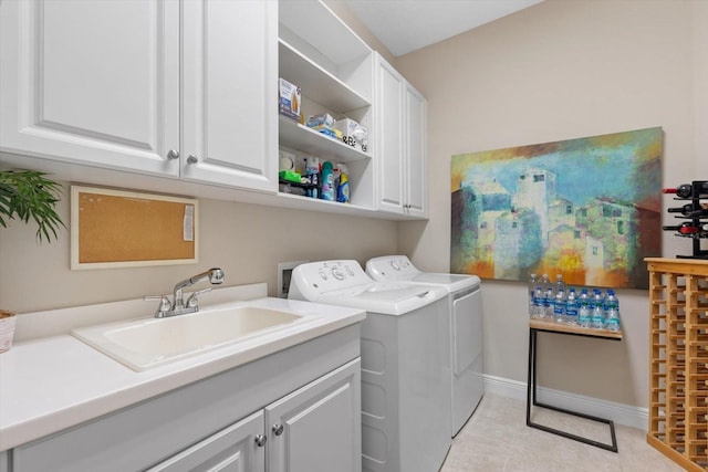 laundry room with light tile patterned floors, cabinets, independent washer and dryer, and sink