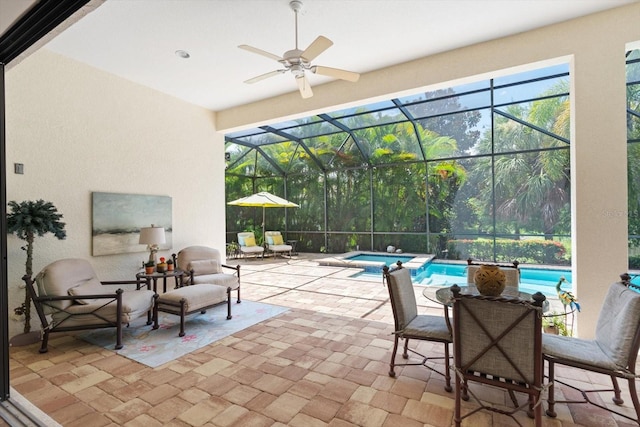 view of patio / terrace featuring a lanai and a swimming pool with hot tub