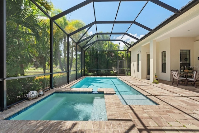 view of pool with a patio area and glass enclosure