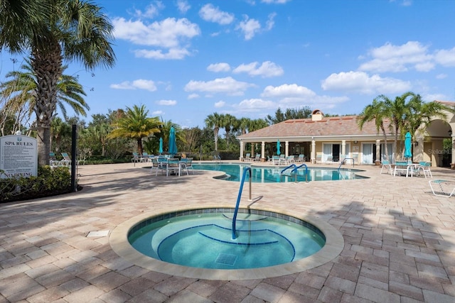 view of pool featuring a hot tub and a patio