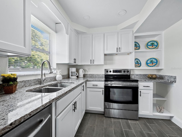 kitchen with a sink, stainless steel appliances, open shelves, and white cabinets